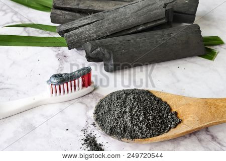 Toothpaste By Activated Charcoal Powder On Marble Table