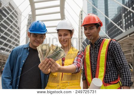 Happy Engineer Team Look At Extra Bonus Money, Us Dollar Bills, After Construction Project Complete 