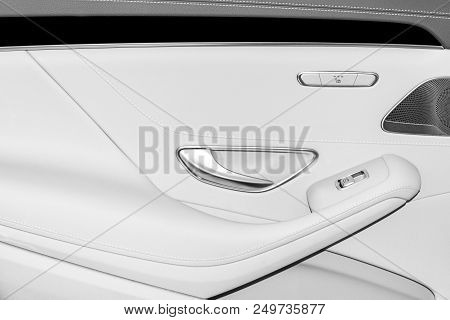 Door Handle With Power Seat And Window Contol Buttons Of A Luxury Passenger Car. White Leather Inter