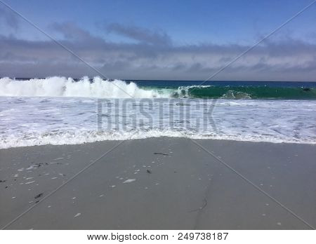 Watching The Teal Blue Waves Of The Pacific Ovean Crash In An Explosion Of White Foam On To A Beach 