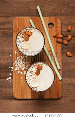 Two Portion Of Banana Smoothies With Oat Flakes, Almond And Banana Chips, Top View