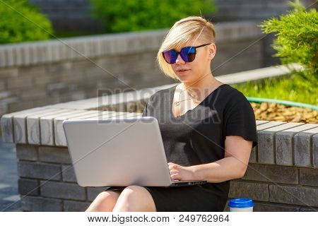 Woman Plus Size Walking Outdoors With Laptop In Sunglasses, Haircut Is Creative. Freelancer Works, L