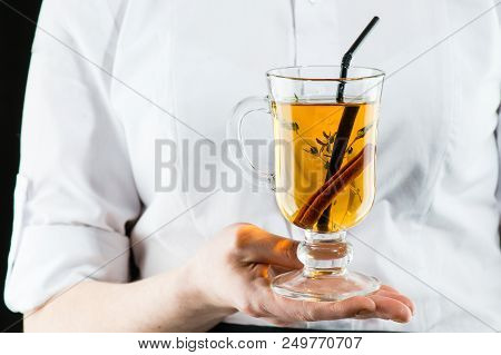 The Unidentified Waiter Holding A Glass With Hot  Amaro Cocktail With Apple Juice And Cinnamon