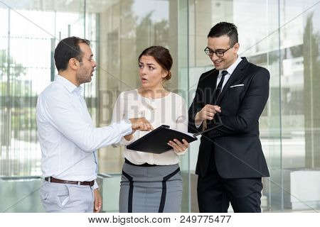 Outraged Entrepreneur Showing Mistake In Business Document To Coworkers. Businessman Is Unhappy With