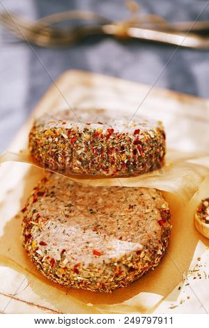lamb burgers spiced by mint and lamb rub on wooded board