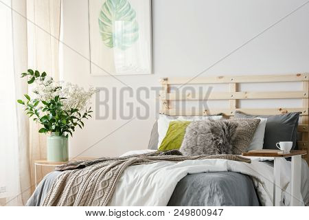 Small Table With Notebook And Coffee Cup Standing By The King-size Bed With Blanket And Fur Pillow I