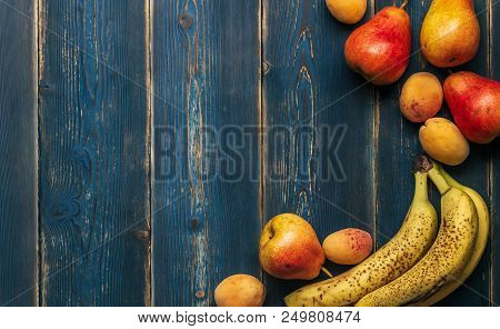 Detox: A Scattering Of Fresh Ripe Bananas, Pears And Apricots On A Wooden Blue Table. Frame With Cop