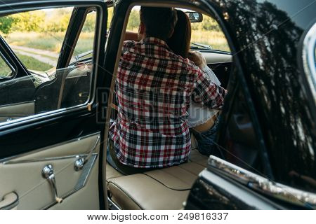 Couple, Man And Woman Are Sitting In The Car, The Guy Is Hugging The Girl. Traveling Together. Check