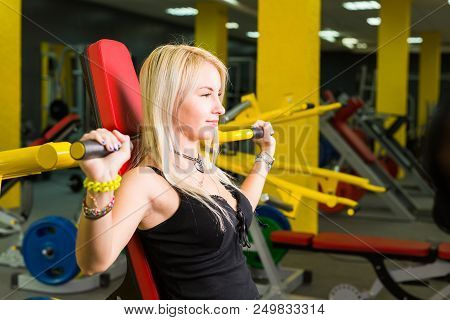 Sport, Fitness, Lifestyle And People Concept - Close Up Of Young Woman Flexing Muscles On Cable Gym 