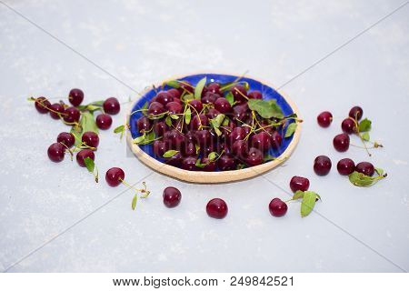 Food Photo. Fresh Ripe Cherries In A Plate And On A Table On A Light Background.