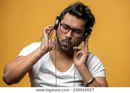 Hindoo Young Man Is Mad At Music Isolated On The Yellow Background. Music Taste. Put Out Song. Hipst