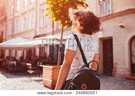 Beautiful College Girl Walking On Summer Street. Young Woman With Backpack Chilling During Holidays 