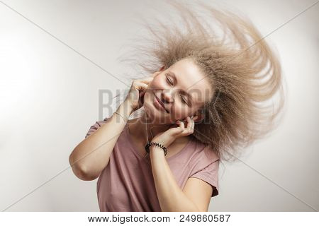 Flying Dancing Hair . Young Charming Woman With Downy Hair In Earphones. Student Is Enjoying The Mus