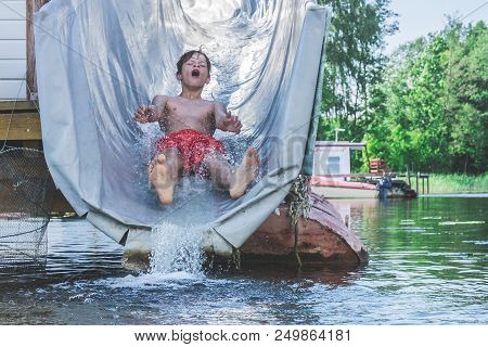 Vilnius, Lithuania - June 2018 - A Boy Slides With A Water Wet Roller Coaster