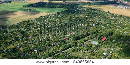 Multiple Allotment Gardens With Little Arbors, Greenhouses, Trees And Bushes, Aerial View.
