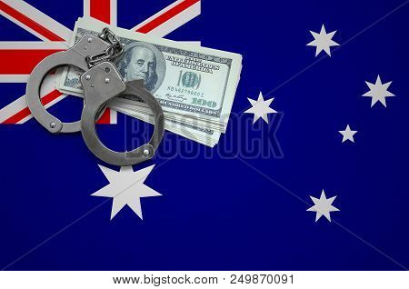 Australia Flag  With Handcuffs And A Bundle Of Dollars. The Concept Of Breaking The Law And Thieves 