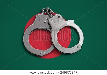 Bangladesh Flag  And Police Handcuffs. The Concept Of Observance Of The Law In The Country And Prote