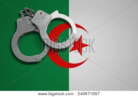 Algeria Flag  And Police Handcuffs. The Concept Of Crime And Offenses In The Country.