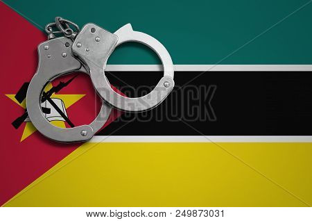 Mozambique Flag  And Police Handcuffs. The Concept Of Crime And Offenses In The Country.