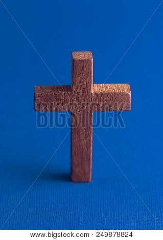 A Simple Wooden Cross On A Blue Background