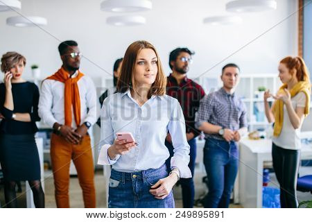 Closeup Side View Shot Of Beautiful Caucasian Woman With Green Eyea And Long Brown Holding Her Mobil
