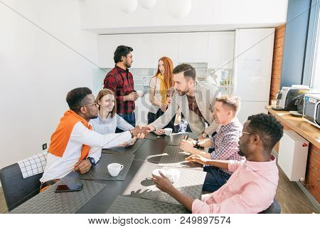 Close-up Photo Of Two Business Men Shaking Hands During Coffee Break In The Modern Canteen