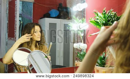 Young Beautiful Girl Curls In The Dressing Room.