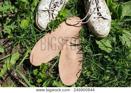 Leather Orthopedic Insoles With Running Shoes On The Grass. Healthy Relax On Nature. Outdoors.