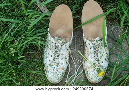 Leather Orthopedic Insoles With Running Shoes On The Grass. Healthy Relax On Nature. Outdoors.