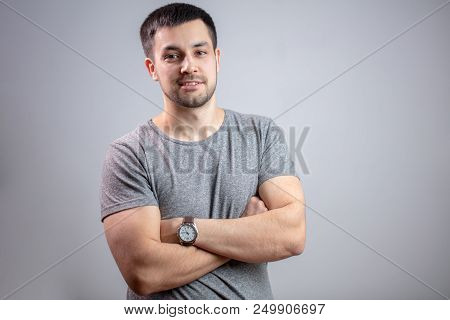 Portrait Of Young Strong Man With Crossed Arms.bodyguard In Casual Outfit. Copy Space. Isolated Grey