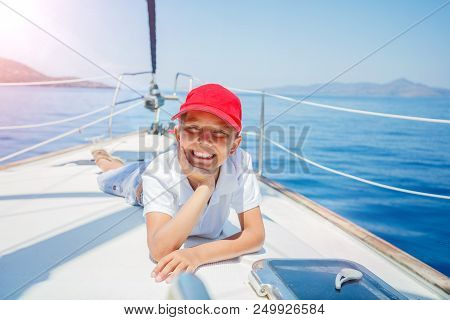 Cute Boy On Board Of Sailing Yacht On Summer Cruise. Travel Adventure, Yachting With Child On Family