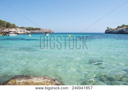 Crystalline Light Blue Sea Speed Boats And Anchor Buoys Of One Little Cove
