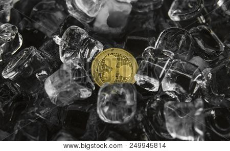 Gold Ripple Coin On Ice Background. The Concept Of The Exchange In Winter. Freeze. Blockchain Mining