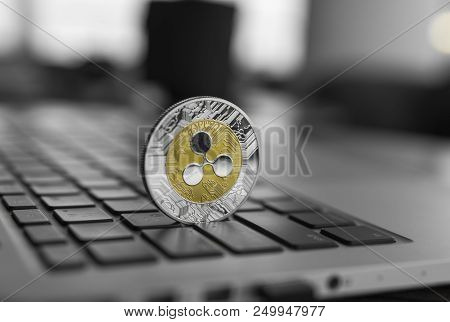 Silver Gold Ripple Coin On A Laptop Keyboard Closeup. Blockchain Mining. Digital Money And Virtual C
