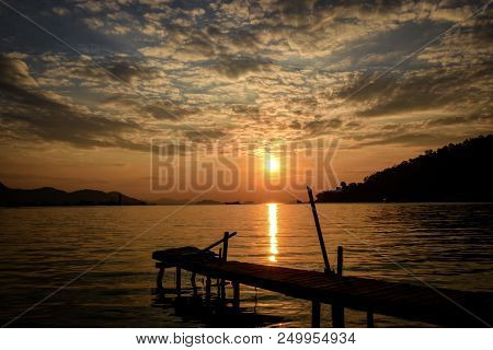 Tropical Sunrise With Wooden Jetty Over Island