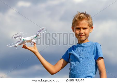 Child Playing With Drone Outdoors Against Blue Sky