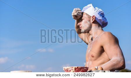 Man Muscular Baker Or Cook Covered With Flour Working Outdoor, Sky On Background. Man With Muscular 