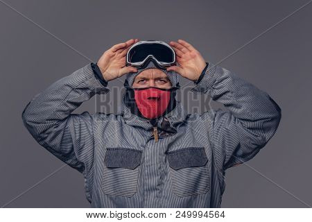 Portrait Of A Snowboarder Dressed In A Full Protective Gear For Extream Snowboarding Puts On Glasses