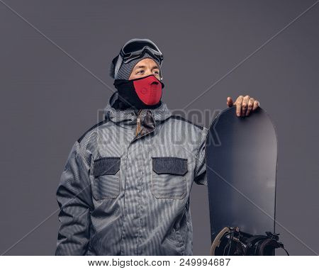 Portrait Of A Snowboarder Dressed In A Full Protective Gear For Extream Snowboarding Posing With Sno