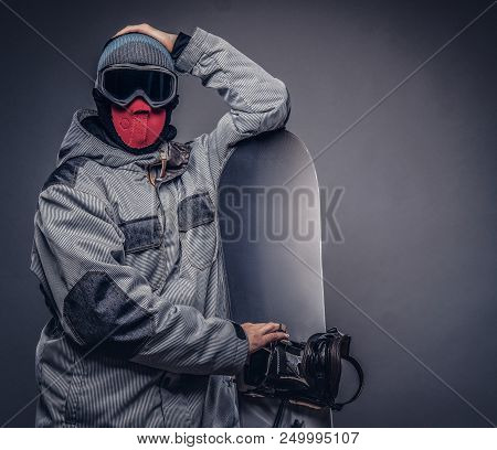 Portrait Of A Snowboarder Dressed In A Full Protective Gear For Extream Snowboarding Posing With Sno