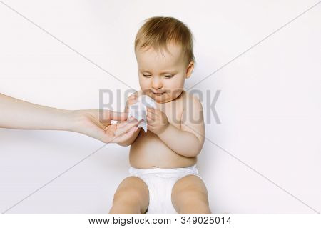 Hygiene - Young Momy Wiping The Baby Skin With Wet Wipes. Little Baby Girl In Diaper Sitting And Tak