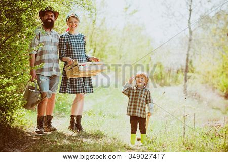 Father Mother And Little Kid Boys Having Fun On Farm In Spring. Family Working Together On Farm