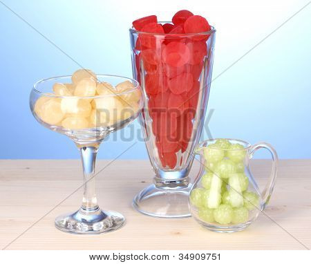 Farve slik i briller på træbord på blå baggrund