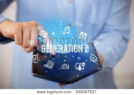 Businessman holding a foldable smartphone with GENERATION Z inscription, social media concept
