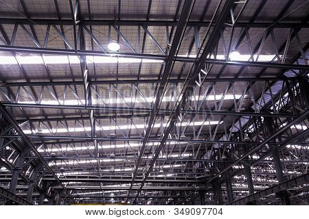 Roof Steel Beam Structure In Industrial Factory, Background Of Factory Ceiling With One Light Blub, 