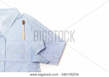 Pajamas Shirt And Wooden Toothbrush On A White Background