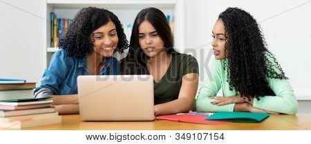 Group Of Latin American And Indian Students Learning At Computer At University