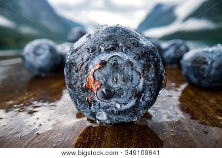 Blueberry antioxidants on a wooden table on a background of Norwegian nature.