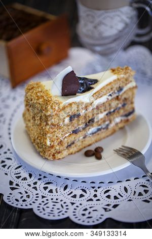 Cake With Honey And Prunes On A White Plate