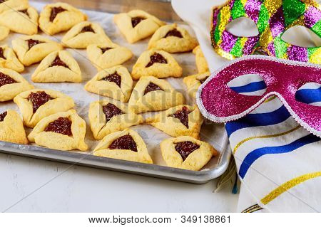 Hamantaschen Jewish Cookies With Jam On Baking Tray With Tallit And Mask For Purim.